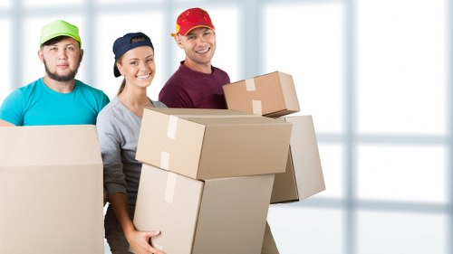 Movers carrying furniture through a Hackney residential property