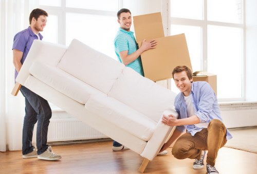 Office desks and storage units being moved through a Hackney building